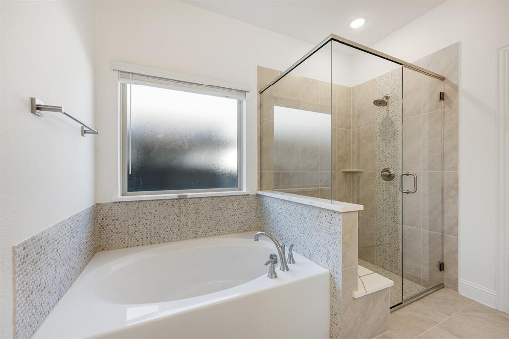 7308 Iris Road Aubrey, TX 76227 - Photo 22 of 40 a bathroom with a bathtub and a shower
