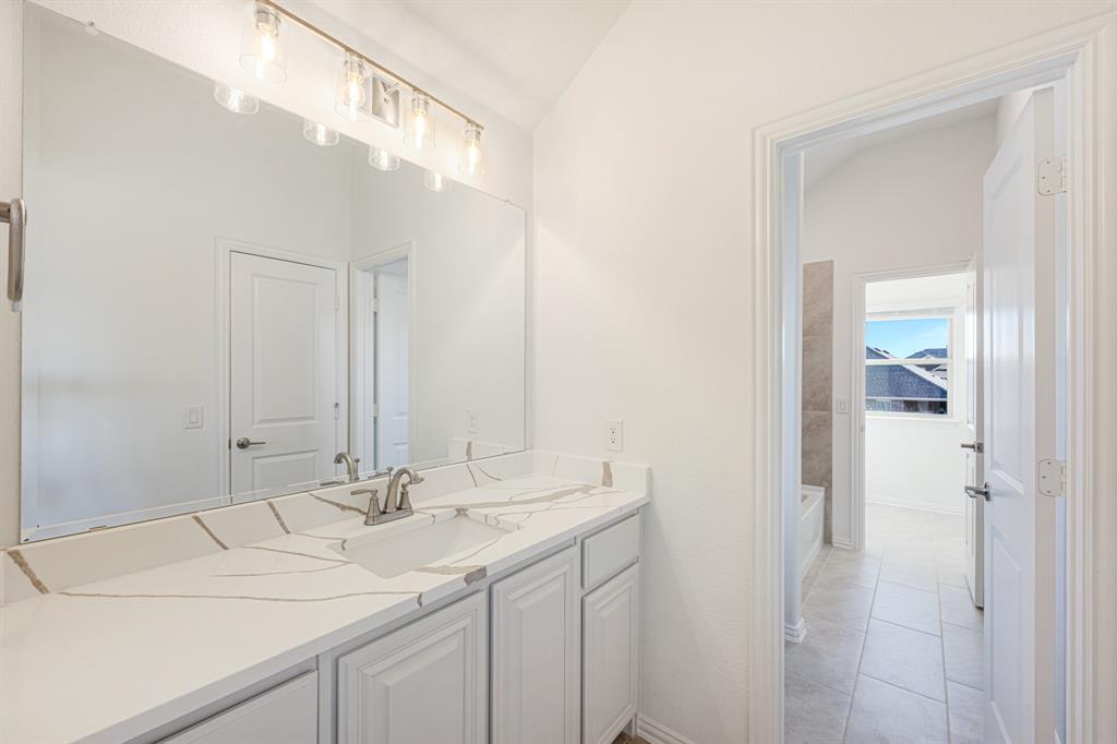 7308 Iris Road Aubrey, TX 76227 - Photo 28 of 40 a bathroom with a sink and a mirror