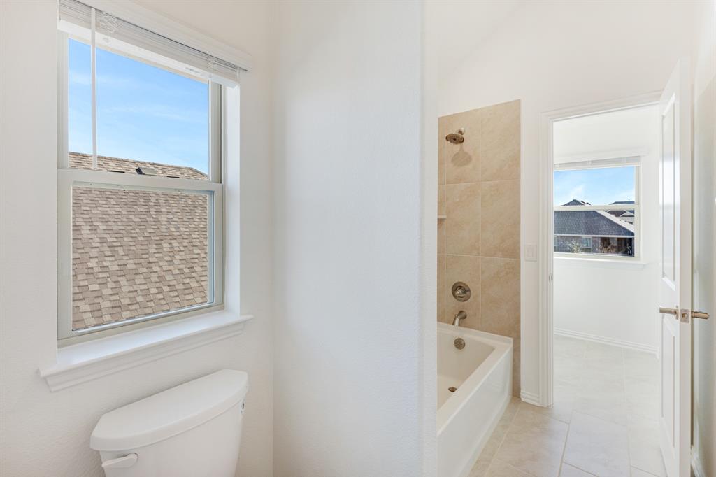 7308 Iris Road Aubrey, TX 76227 - Photo 29 of 40 a bathroom with a bathtub and a shower