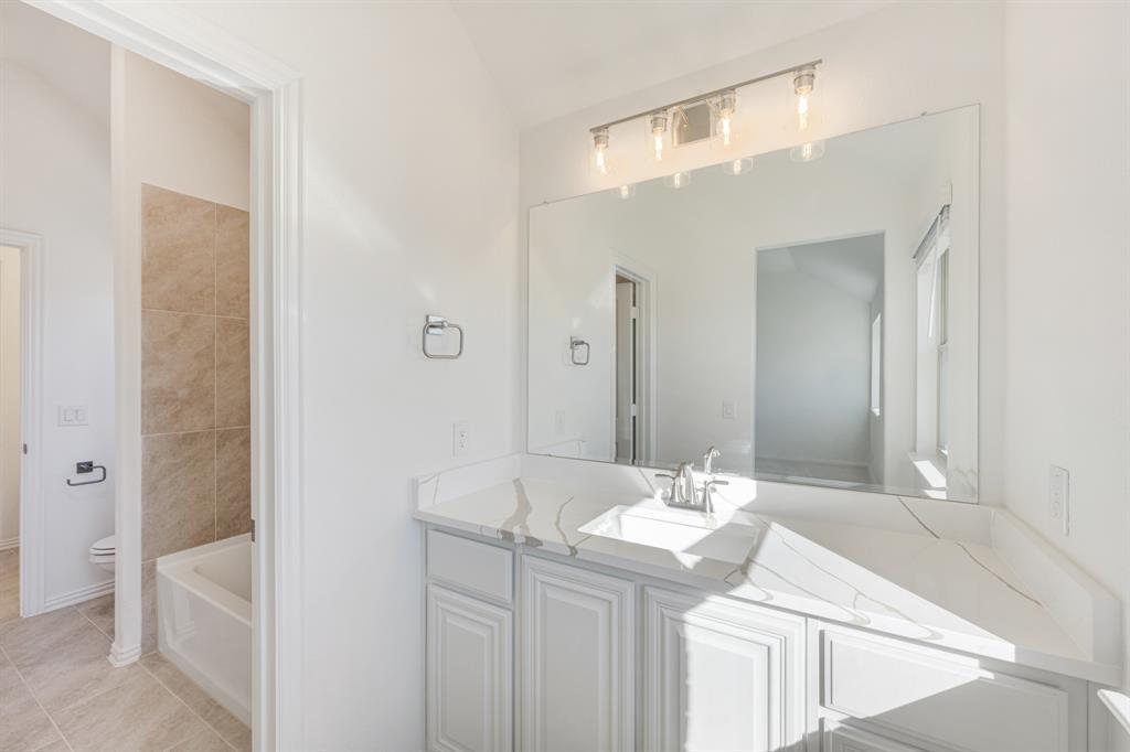 7308 Iris Road Aubrey, TX 76227 - Photo 30 of 40 a bathroom with a sink a toilet and shower