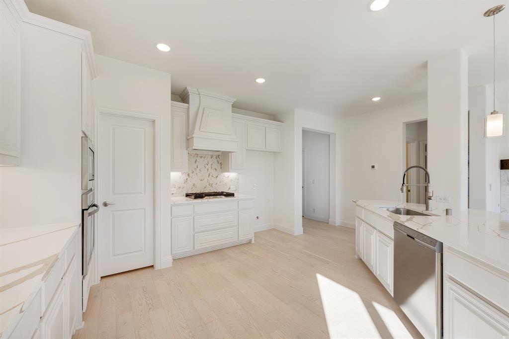7308 Iris Road Aubrey, TX 76227 - Photo 10 of 40 a large white kitchen with stainless steel appliances