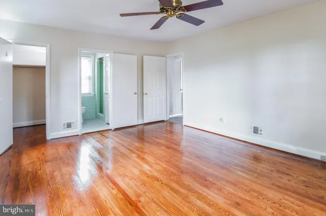 a view of a room with wooden floor and white walls