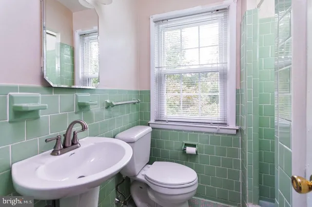 a bathroom with a sink a toilet and a mirror