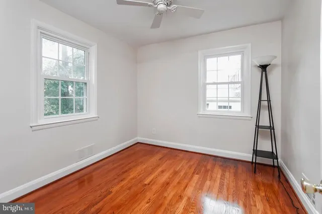 an empty room with a window and wooden floor