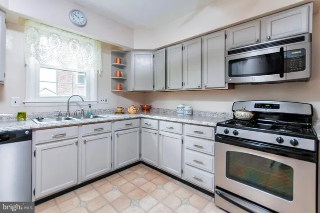 a kitchen with cabinets stainless steel appliances and a window