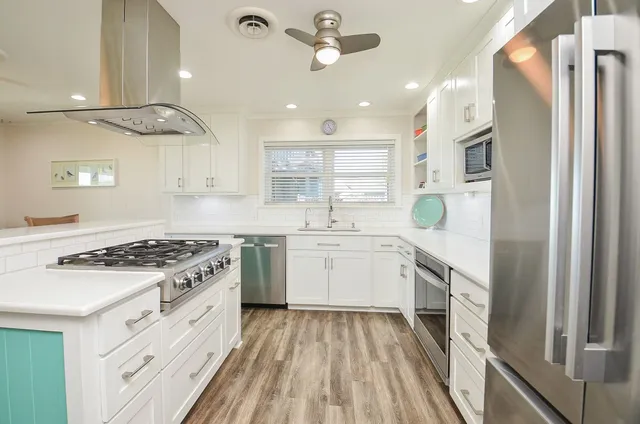 a kitchen with stainless steel appliances granite countertop a stove and a sink
