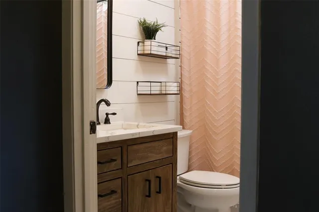 a bathroom with a sink a toilet and shower curtain