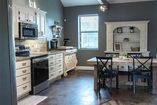a kitchen with stainless steel appliances granite countertop a stove and cabinets