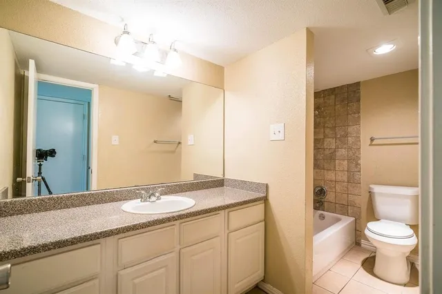 a bathroom with a granite countertop sink toilet a large mirror a shower and vanity