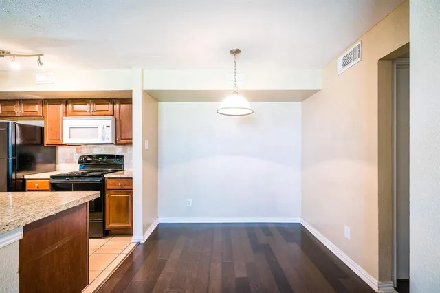 a kitchen with a refrigerator and a stove top oven