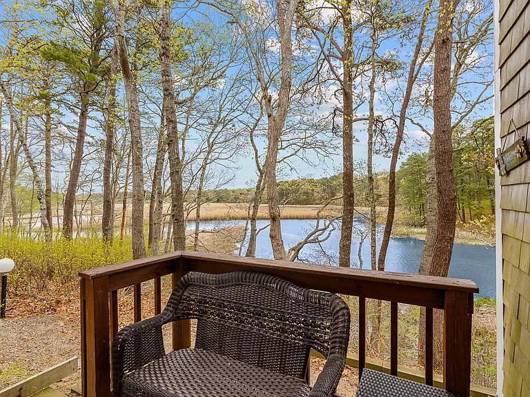 15 Riverview Avenue, Unit D Mashpee, MA 02649 - Photo 21 of 33 a view of roof deck with large trees and wooden fence