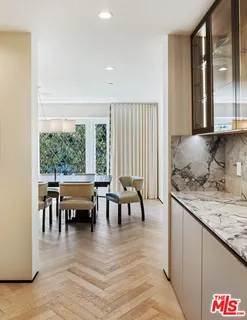 a very nice looking dining room with a large window and wooden floor