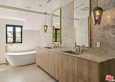 a bathroom with a granite countertop sink mirror and a bathtub