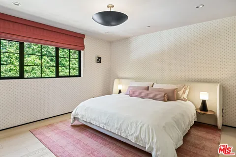 a bedroom with a large bed and a large window