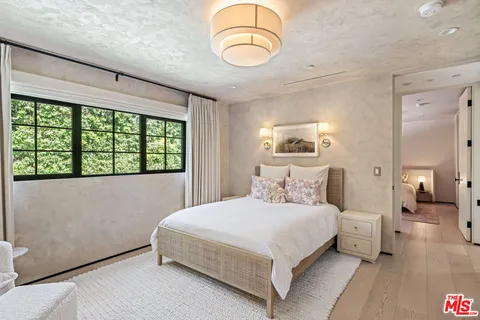 a bedroom with a large bed and a chandelier