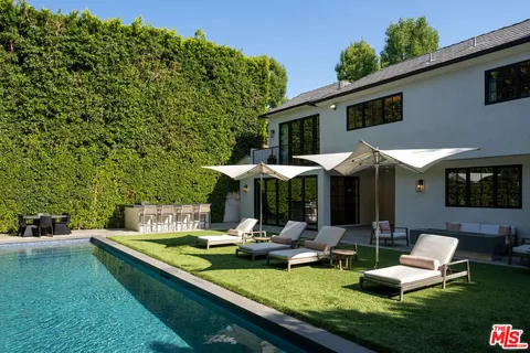 a view of a house with backyard sitting area and swimming pool