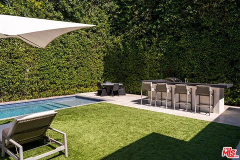 a view of a chairs and table in the backyard