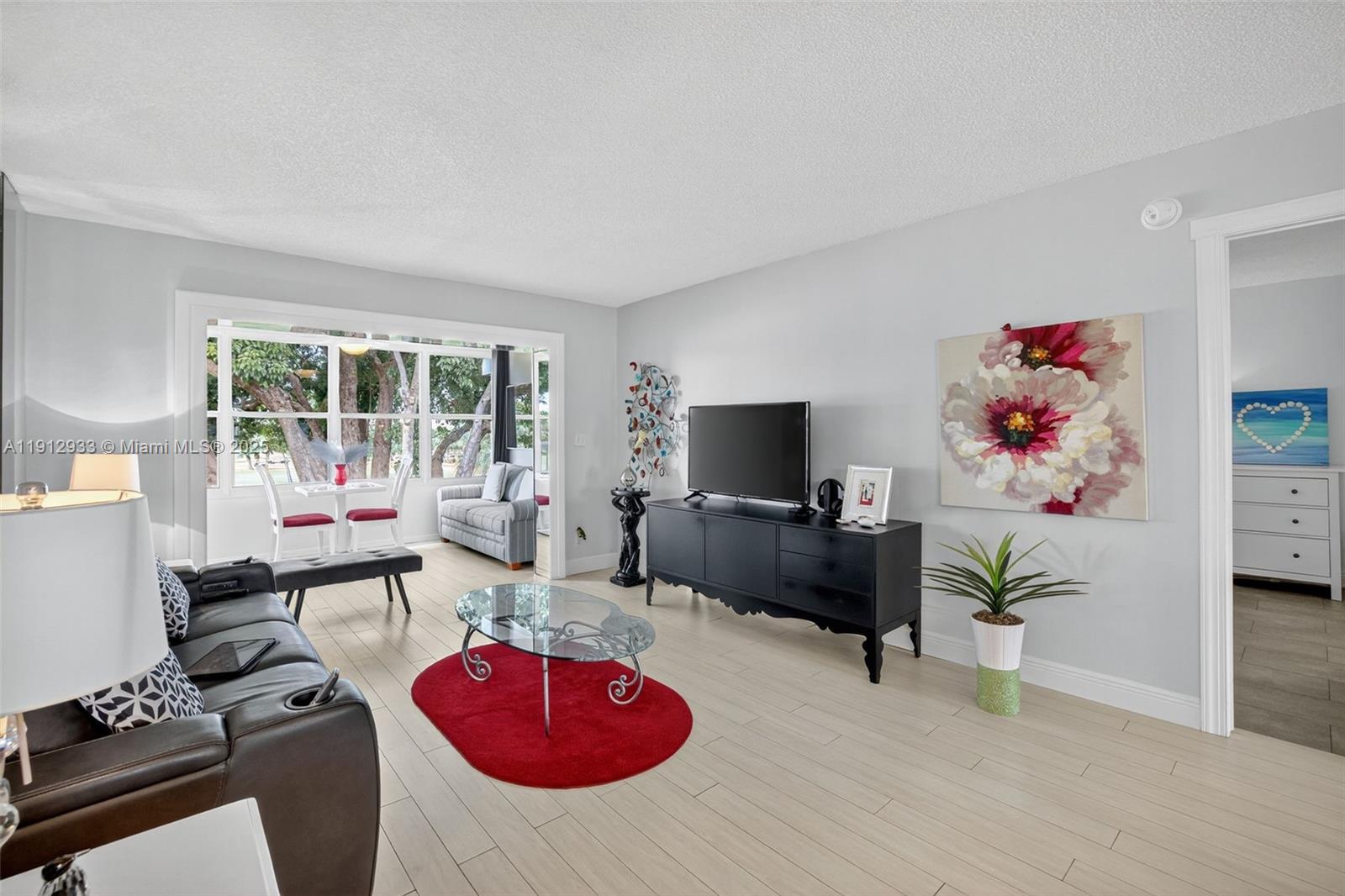 7817 Golf Cir Drive, Unit 305 Margate, FL 33063 - Photo 4 of 43 a living room with furniture and a flat screen tv