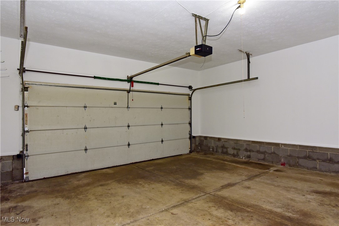 2276 Raber Road, Unit F Uniontown, OH 44685 - Photo 30 of 30 Garage featuring a garage door opener and concrete block wall
