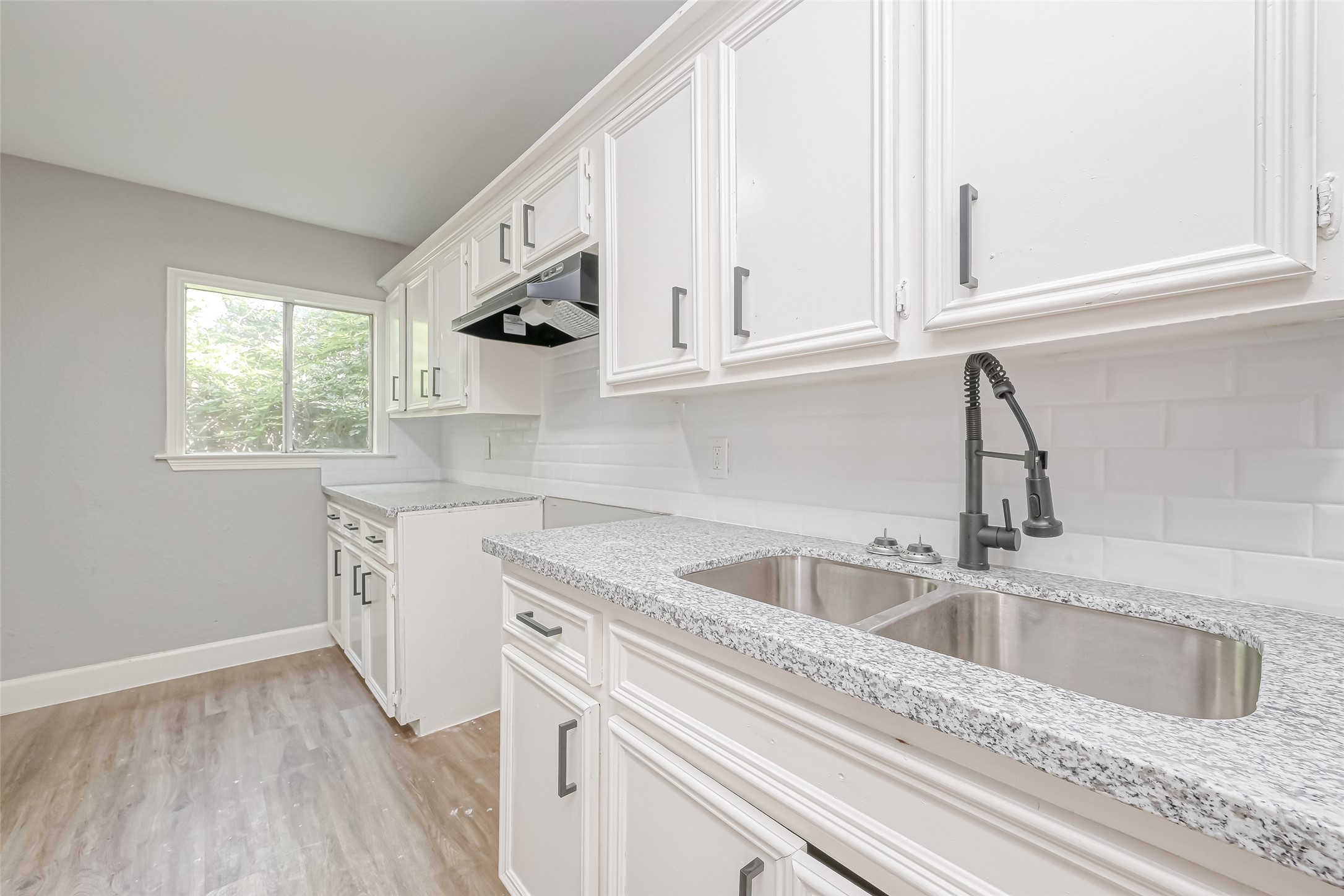 6715 Victoria Street Houston, TX 77020 - Photo 35 of 46 a kitchen with stainless steel appliances granite countertop a sink dishwasher and white cabinets with wooden floor