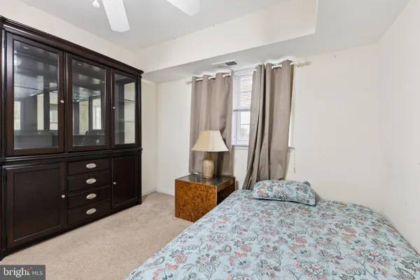 a bedroom with a bed dresser and a large mirror