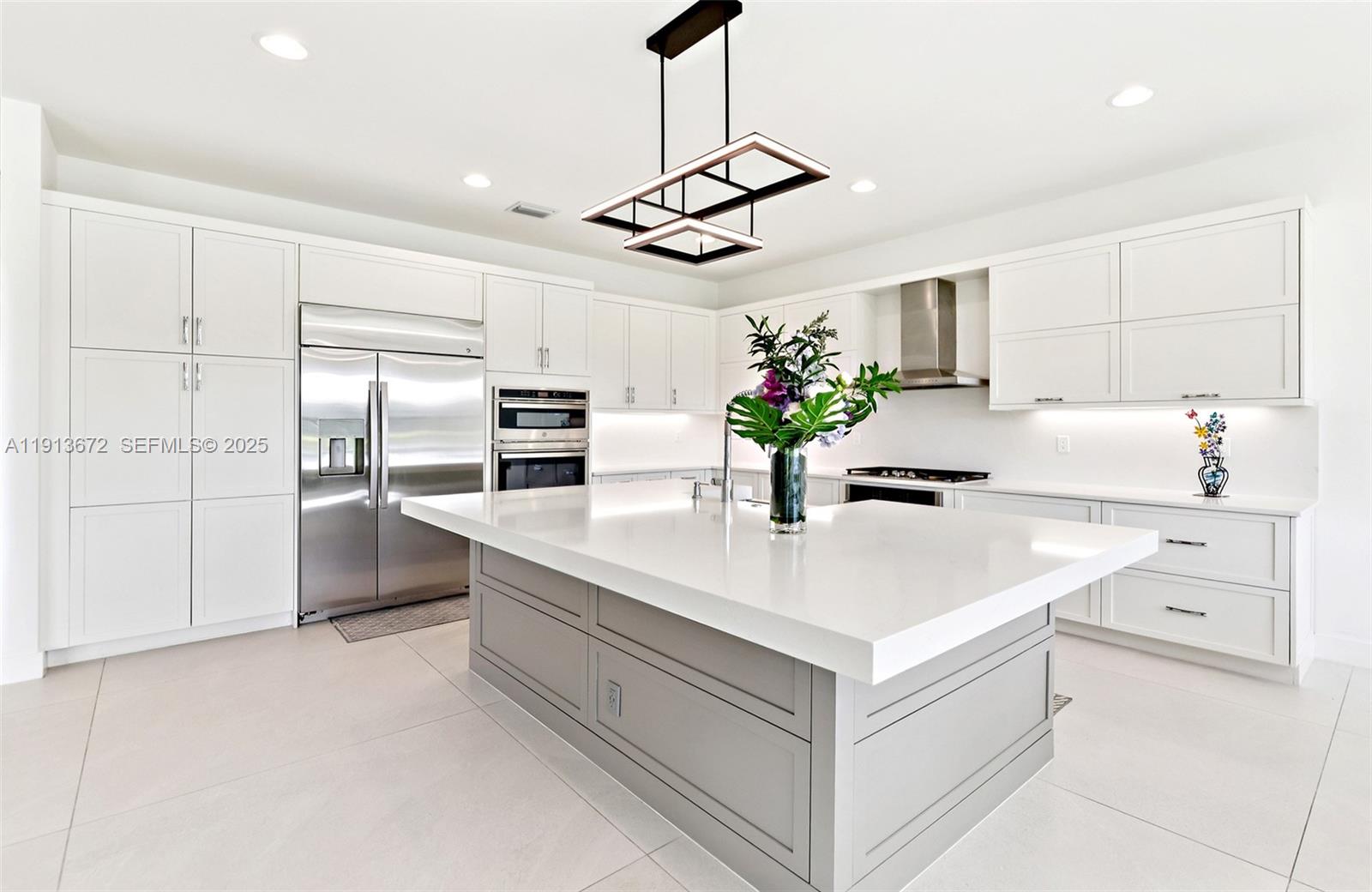 17182 Windy Pointe Lane Boca Raton, FL 33496 - Photo 8 of 13 a kitchen with kitchen island white cabinets and refrigerator