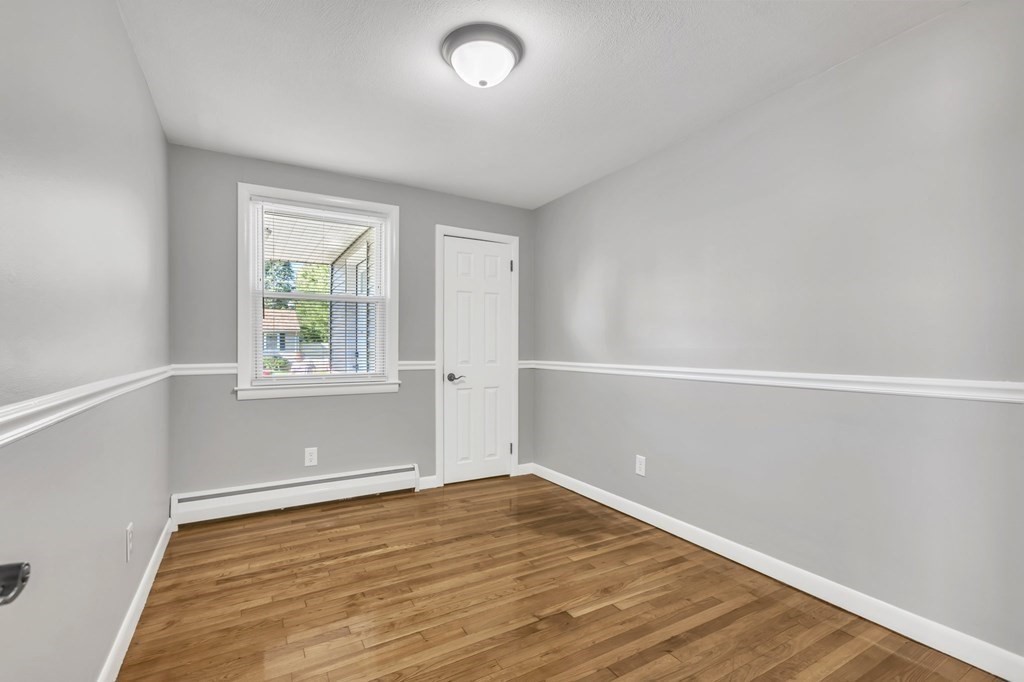172 Garvey Drive Springfield, MA 01109 - Photo 15 of 28 an empty room with wooden floor and windows