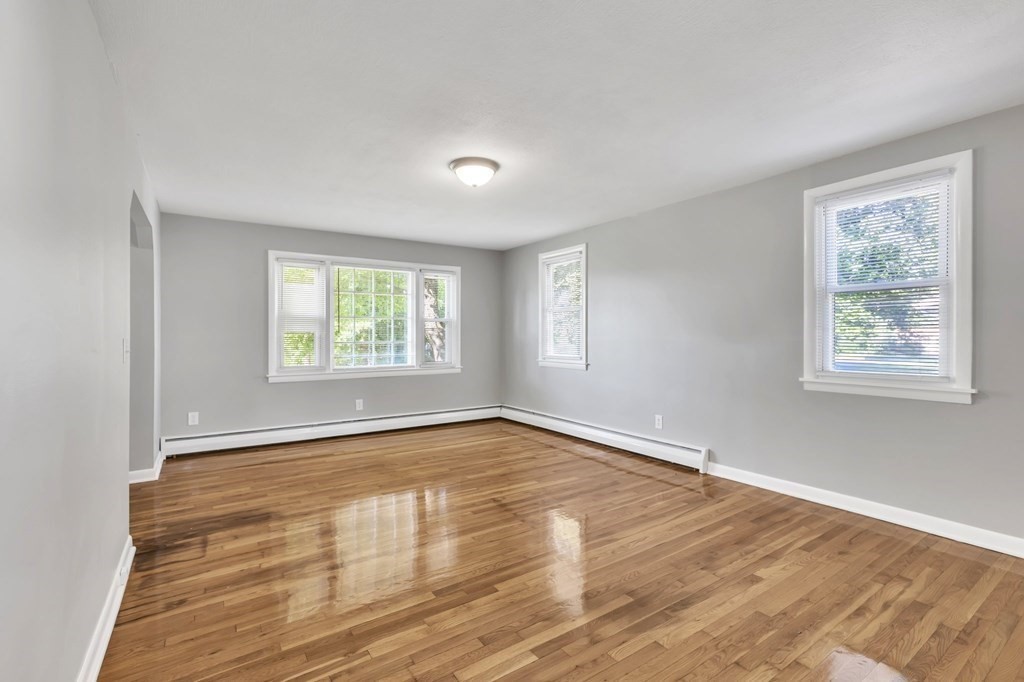172 Garvey Drive Springfield, MA 01109 - Photo 2 of 28 an empty room with wooden floor and windows