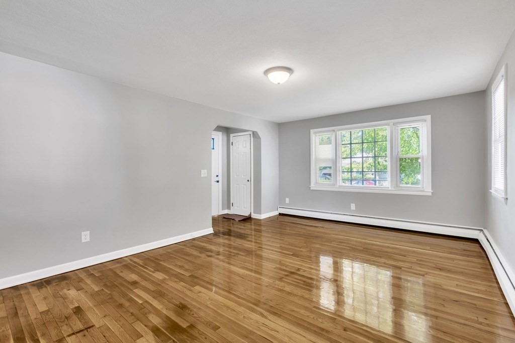 172 Garvey Drive Springfield, MA 01109 - Photo 3 of 28 an empty room with wooden floor and windows