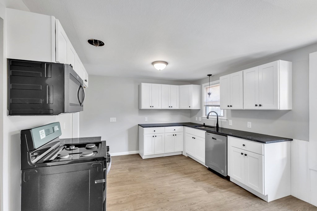 172 Garvey Drive Springfield, MA 01109 - Photo 6 of 28 a kitchen with granite countertop white cabinets and stainless steel appliances