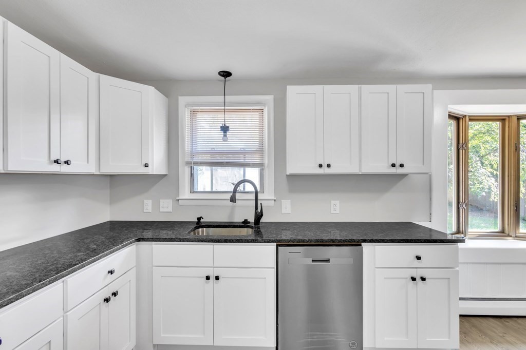 172 Garvey Drive Springfield, MA 01109 - Photo 7 of 28 a kitchen with granite countertop white cabinets white stainless steel appliances and a sink