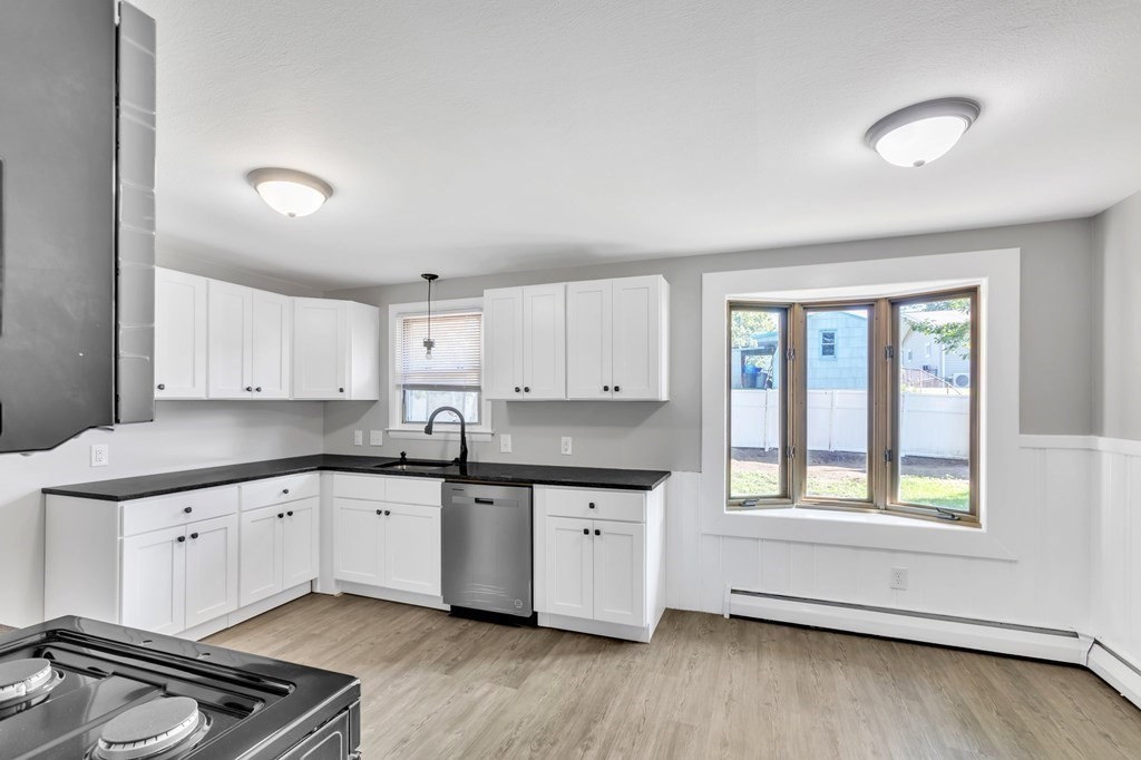 172 Garvey Drive Springfield, MA 01109 - Photo 8 of 28 a kitchen with granite countertop a sink cabinets and window