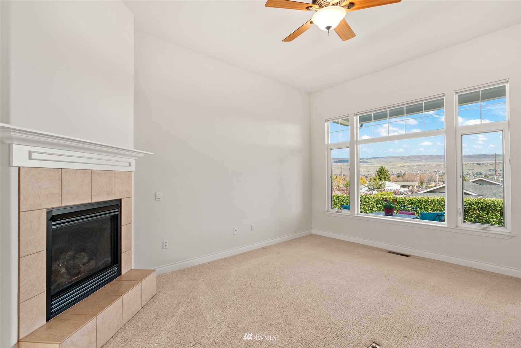 1845 Maple Street, Unit 9 Wenatchee, WA 98801 - Photo 9 of 20 an empty room with fireplace and fan