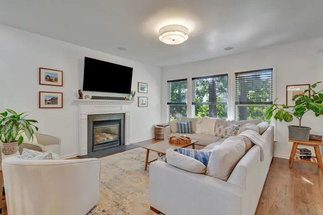 a living room with furniture a flat screen tv and a fireplace