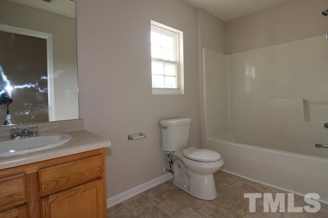 2620 Quarry Ridge Lane Raleigh, NC 27610 - Photo 17 of 25 a bathroom with a granite countertop toilet a sink and a mirror