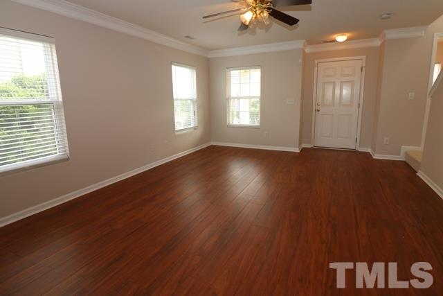 2620 Quarry Ridge Lane Raleigh, NC 27610 - Photo 3 of 25 an empty room with wooden floor chandelier fan and windows