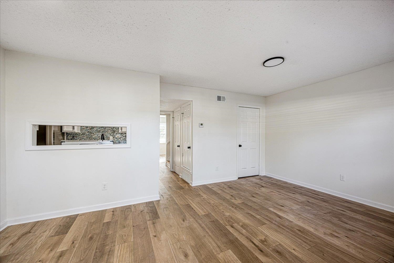 6452 Macon Road Memphis, TN 38134 - Photo 12 of 22 Empty room featuring a textured ceiling and wood finished floors