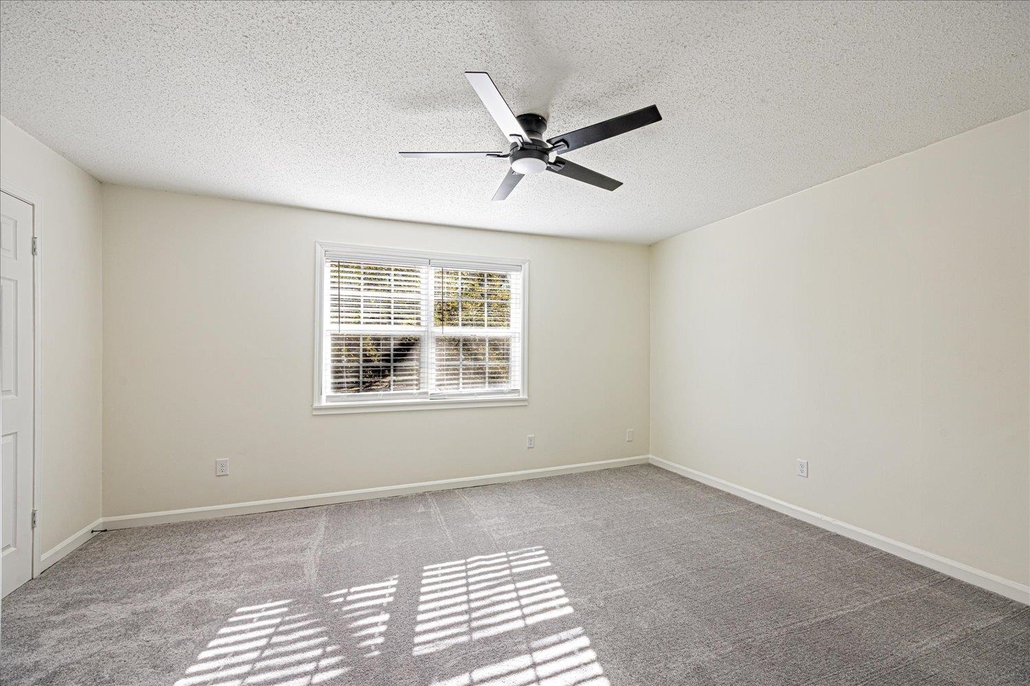6452 Macon Road Memphis, TN 38134 - Photo 13 of 22 Empty room with a textured ceiling, light colored carpet, and a ceiling fan