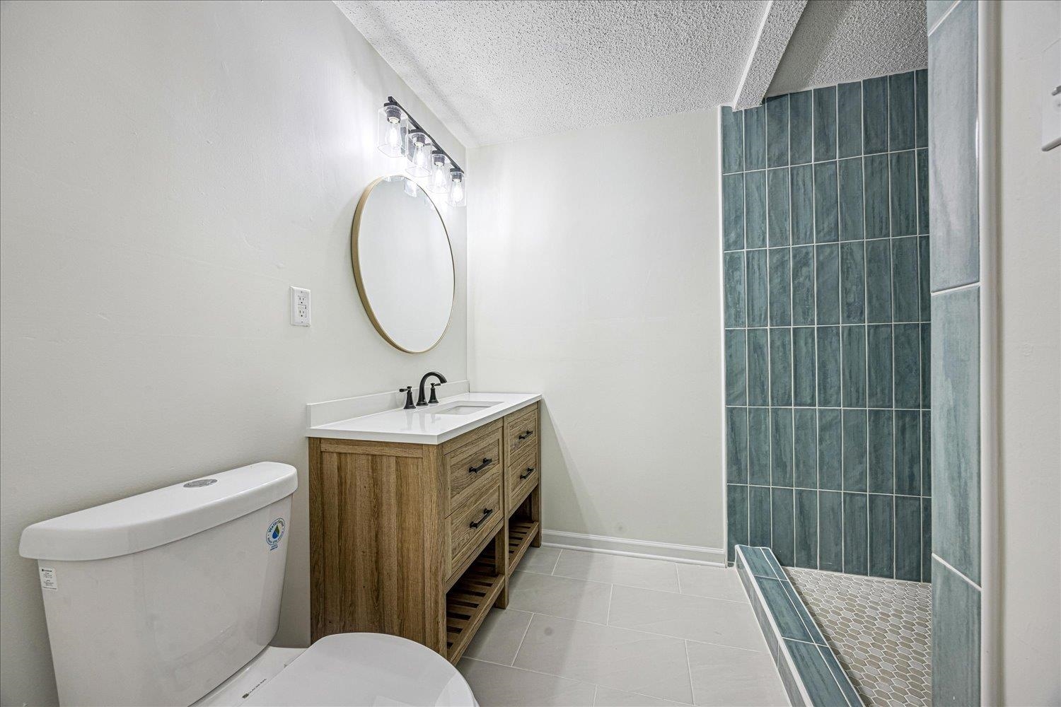 6452 Macon Road Memphis, TN 38134 - Photo 15 of 22 Bathroom with light tile patterned flooring, a shower stall, vanity, and a textured ceiling