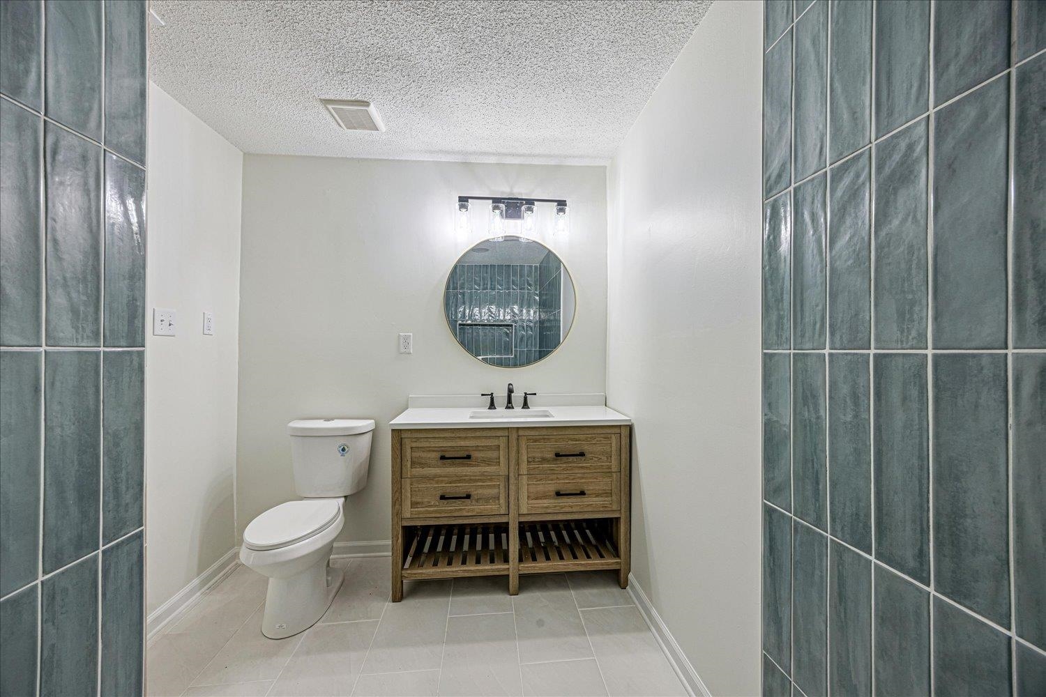 6452 Macon Road Memphis, TN 38134 - Photo 17 of 22 Full bathroom with vanity, light tile patterned flooring, and a textured ceiling