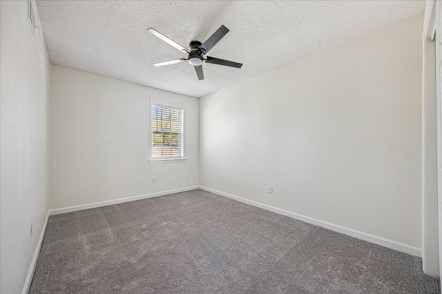 6452 Macon Road Memphis, TN 38134 - Photo 18 of 22 Empty room with a textured ceiling, dark carpet, and ceiling fan
