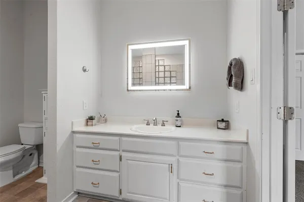 a bathroom with a toilet sink and mirror