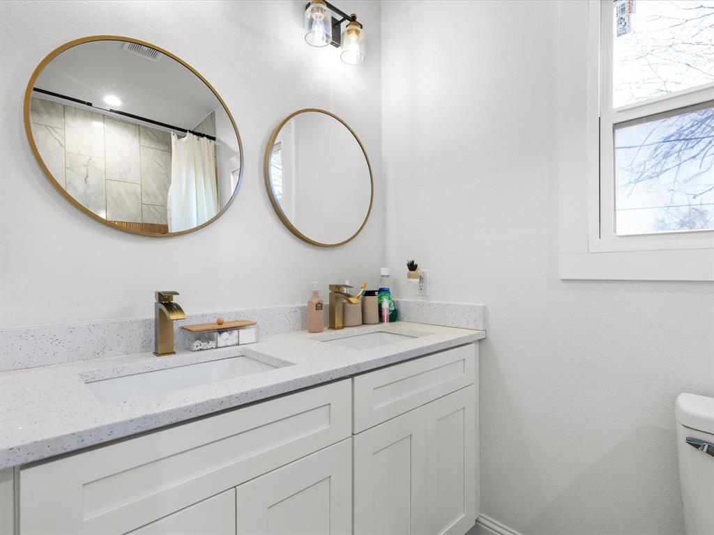 1304 East Mulkey Street Fort Worth, TX 76104 - Photo 16 of 19 a bathroom with a sink and a mirror