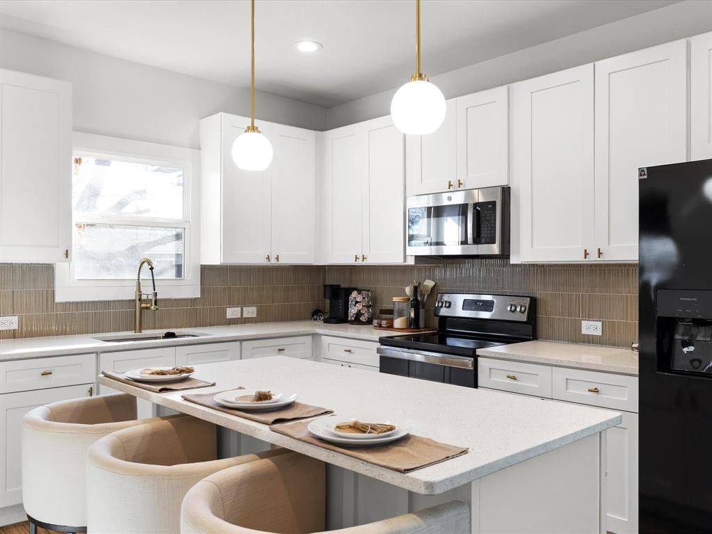 1304 East Mulkey Street Fort Worth, TX 76104 - Photo 3 of 19 a kitchen with stainless steel appliances a stove a sink and a refrigerator