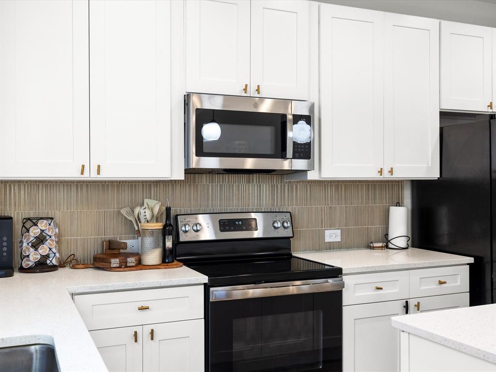 1304 East Mulkey Street Fort Worth, TX 76104 - Photo 6 of 19 a kitchen with a stove and a microwave