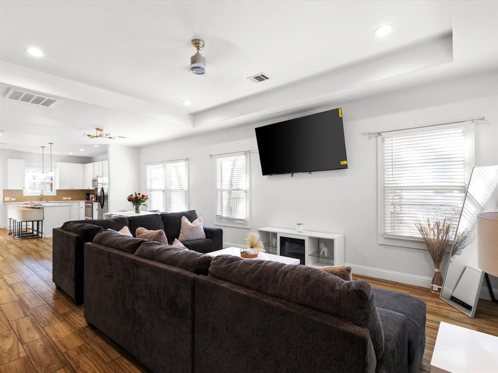 1304 East Mulkey Street Fort Worth, TX 76104 - Photo 8 of 19 a living room with furniture a flat screen tv and a window