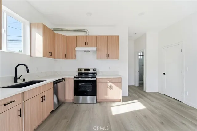 a kitchen with a refrigerator sink and cabinets