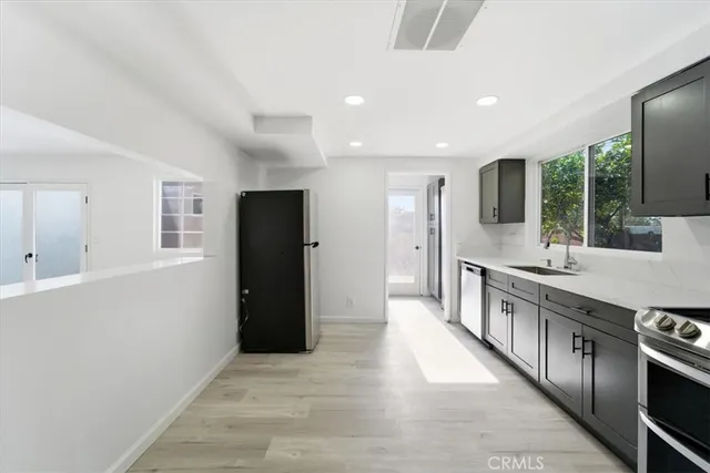 a kitchen with stainless steel appliances granite countertop a sink a stove and a refrigerator