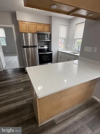 a view of kitchen with refrigerator and wooden floor