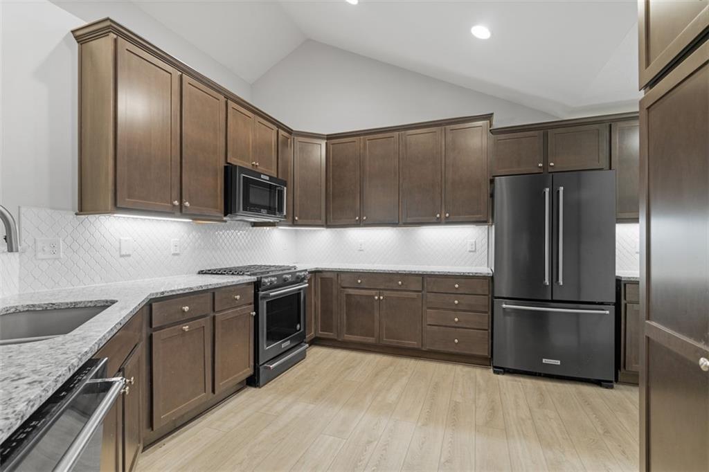 103 Spring Valley Drive Zelienople, PA 16063 - Photo 9 of 42 a kitchen with granite countertop stainless steel appliances and wooden cabinets